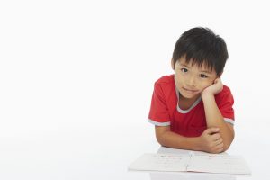 Boy lying on his front, studying